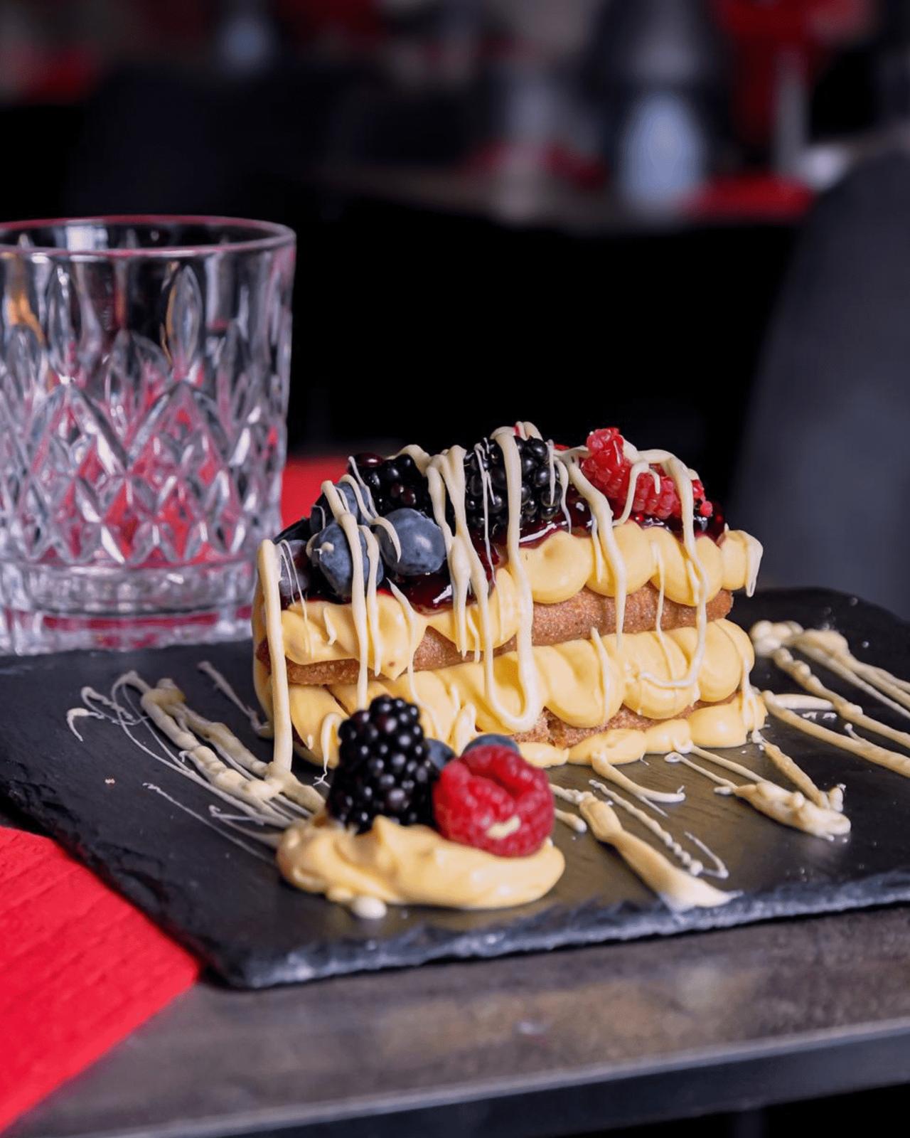 Mixed-berry tiramisù with blackberries, raspberries and drizzled white cream